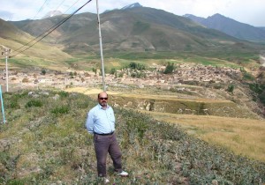 محمد درویش در کنار چشم اندازی از روستای موئیل